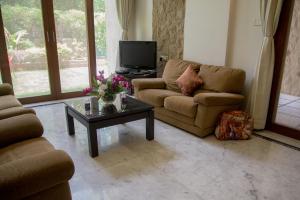 a living room with a couch and a coffee table at Hermitage Suites Koregaon Park Garden & Terrace Room in Pune