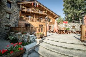 a log cabin with a staircase leading to the front of it at Mont Avic Resort & Wellness in Champdepraz
