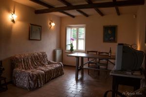 a living room with a couch and a table and a tv at Coriana Apartments & Villas in Mulazzo