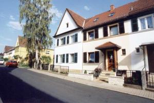 una casa blanca con un coche rojo estacionado en una calle en Pension a la Kleinert, en Weimar