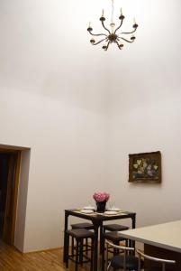 クルジュ・ナポカにあるContessa Central Apartmentのダイニングルーム(テーブル、椅子、シャンデリア付)