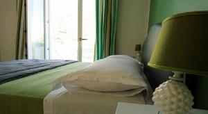 1 dormitorio con 1 cama con ventana y lámpara en Il Miracolo, en Maiori