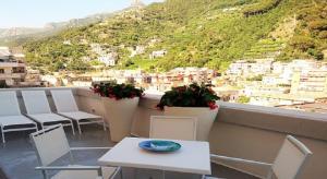 Una mesa y sillas en un balcón con vista. en Il Miracolo, en Maiori