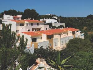 a group of houses on a hill with trees at Seaview Apartments in Salema