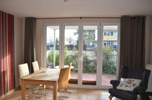 a dining room with a table and chairs and a window at Ferienwohnung Maigloeckchen 05 str in Karlshagen