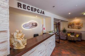 a lobby of a restaurant with a statue on the counter at Hotel Świeradów in Świeradów-Zdrój