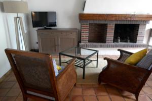 a living room with chairs and a table and a fireplace at Domaine d'Adon in Adon