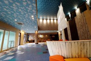 a lobby with orange chairs and a blue ceiling at La'gent Hotel Tokyo Bay in Urayasu