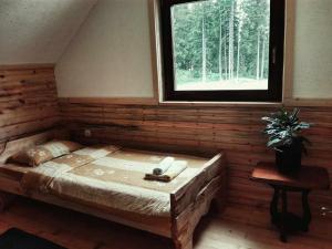 a bed in a wooden room with a window at Woden apartment in Žabljak