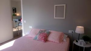 Un dormitorio con una cama rosa con almohadas. en La Devesa de Gerona, en Girona