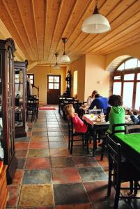 un groupe de personnes assises à des tables dans un restaurant dans l'établissement Argyro Guesthouse - Ξενώνας Αργυρώ, à Nymfaio 26 autres photos