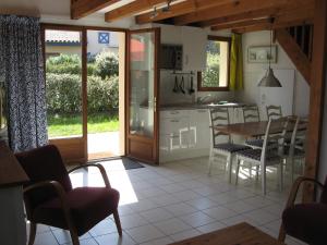a kitchen and dining room with a table and chairs at Park Village Océlandes in Saint-Julien-en-Born