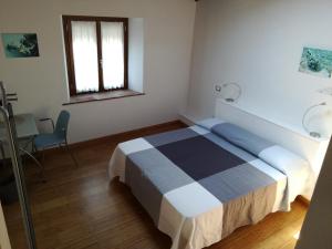 a bedroom with a bed and a table and a window at B & B Via di Mezzo in Coreglia Antelminelli