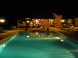 una piscina por la noche con luces. en Les Gîtes de La Treille en Montagrier