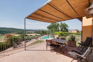 eine Terrasse mit einem Tisch und Stühlen sowie Aussicht in der Unterkunft Umbria Country Shelter in Compignano