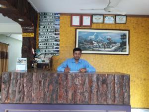 Un uomo seduto al bancone in un ristorante di Hello Inn Guest House & Apartment a Pokhara