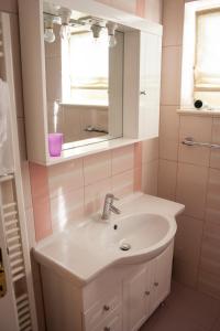 uma casa de banho com um lavatório e um espelho em Apartments Mirage em Novalja
