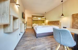 a bedroom with a bed and a desk and a chair at Appartement Bella Vista in Saalbach Hinterglemm