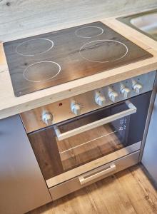 a stove top oven with a wooden counter top at Appartement Bella Vista in Saalbach Hinterglemm