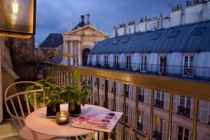 een tafel op een balkon met uitzicht op een gebouw bij Le Pradey in Parijs