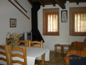 a living room with a table and chairs and a television at Cal Pedrals in Puigcerdà