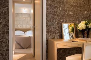 - une chambre avec un lit et un miroir mural dans l'établissement Le Pradey, à Paris