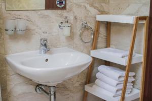 a bathroom with a sink and a bunch of towels at Penzión Kúria in Nové Mesto nad Váhom