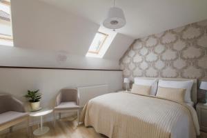 a bedroom with a white bed and a window at Penzión Kúria in Nové Mesto nad Váhom