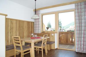 a dining room with a table and chairs and a window at Singerhof in Fulpmes