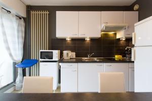 マンドリュー・ラ・ナプールにあるRana's flatのキッチン(白いキャビネット、青い椅子付)