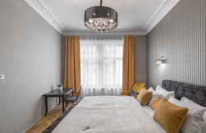 sypialnia z łóżkiem, stołem i żyrandolem w obiekcie Mordecai 12 Apartments by Adrez w Pradze
