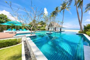 a swimming pool with a view of the ocean at Beachfront Villa Baan Paradise in Laem Set Beach