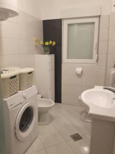 a white bathroom with a washing machine and a sink at Voshta 2 bedroom apartment in Zadar +16 photos