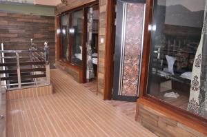 a room with wooden walls and windows and a wooden floor at Ekam Lodge in Nainital