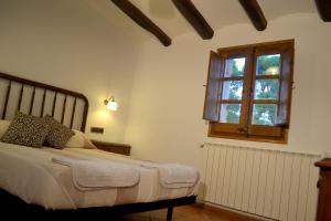 um quarto com uma cama e uma janela em Can Cruset agroturisme em Torrellas de Foix