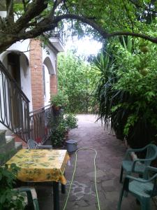 a patio with a table and chairs under a tree at House on Anagnino 64 in Ciampino