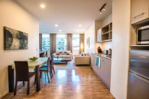 a kitchen and living room with a table and chairs at Quest On Lambton Serviced Apartments in Wellington