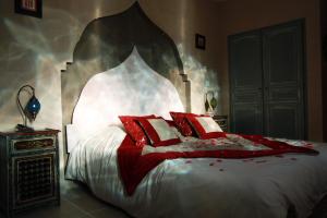 1 dormitorio con 1 cama grande con almohadas rojas en Domaine la Chamade, en Carpentras