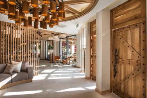 a hallway with a wooden door and a chandelier at Blu Bay Hotel Sozopol in Sozopol
