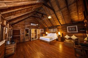una camera da letto con un letto in una cabina di legno di Aliya Resort and Spa - Thema Collection a Sigiriya