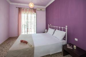 キサモスにあるCisamon Apartmentの紫の壁のベッドルーム1室(白いベッド1台付)