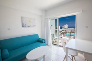 un soggiorno con divano blu e tavolo di Papantonia Hotel a Protaras