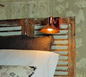 a lamp hanging over a bed with a head board at Aquarelle in Sainte-Maure-de-Touraine