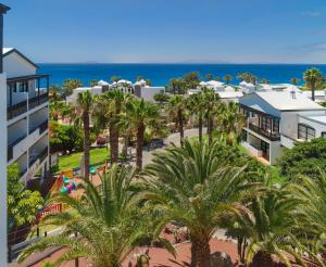 an aerial view of a resort with palm trees and the ocean at H10 Rubicón Palace in Playa Blanca