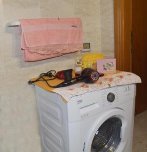 クストナーチにあるLa casa tra mare e collinaのバスルーム(ピンクのタオル付)の洗濯機
