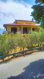 una casa amarilla al lado de una carretera en Il girasole en Castel Ritaldi