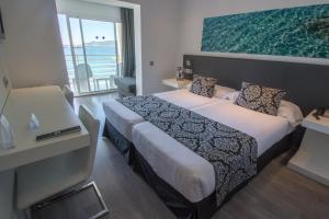 ein Hotelzimmer mit einem Bett und einem großen Fenster in der Unterkunft BG Nautico Ebeso in Ibiza-Stadt