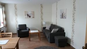 sala de estar con sofá, 2 sillas y mesa en Ferienwohnung Ortsmitte-Willingen, en Willingen