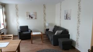 ein Wohnzimmer mit einem Sofa, 2 Stühlen und einem Tisch in der Unterkunft Ferienwohnung Ortsmitte-Willingen in Willingen