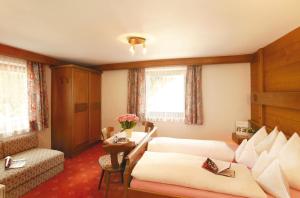 a hotel room with two beds and a couch at Pezinerblick in Ischgl